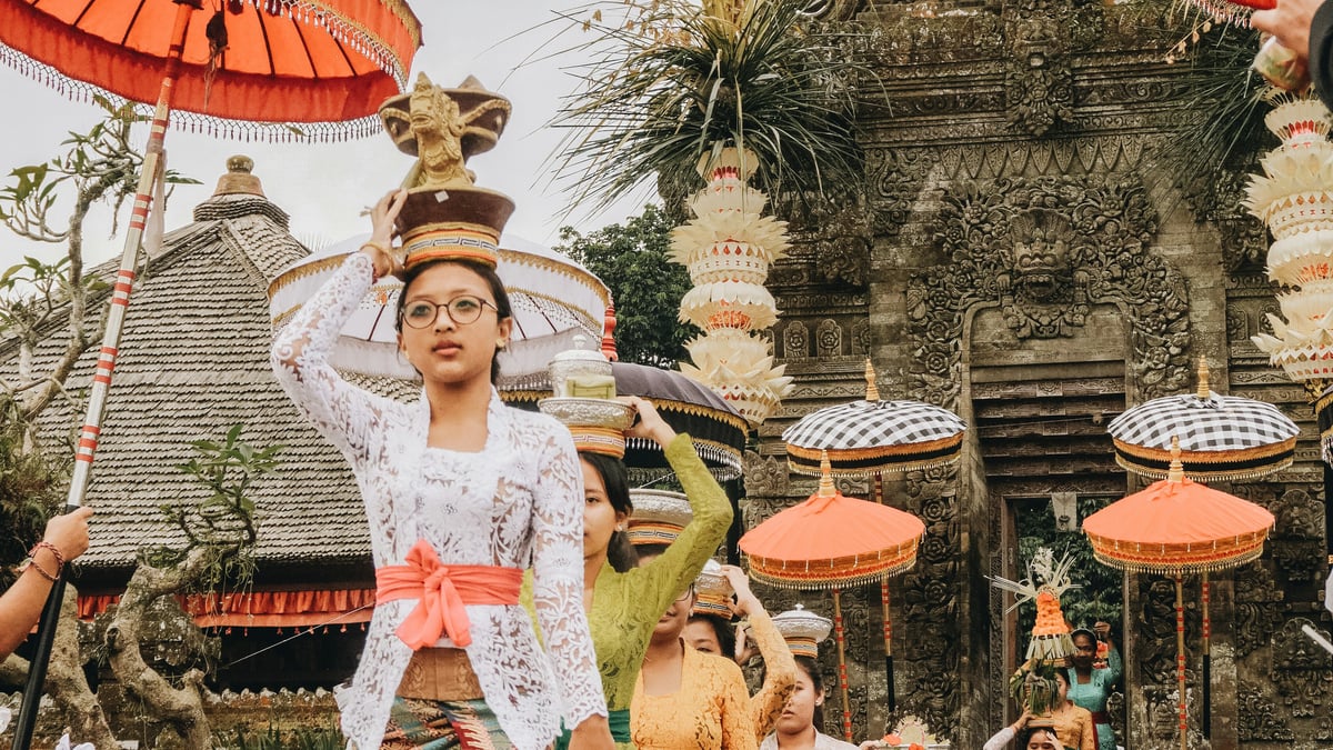 Women in traditional dress carrying offerings on their heads during a ceremony at a temple in Bali